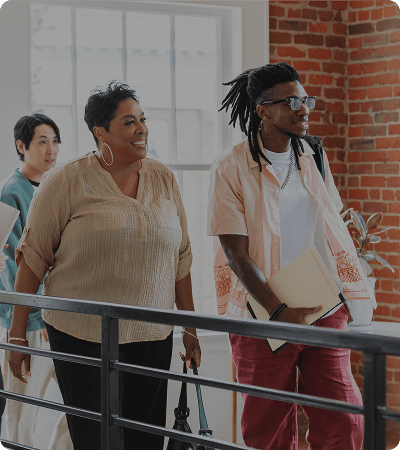 Group smiling indoors near brick wall