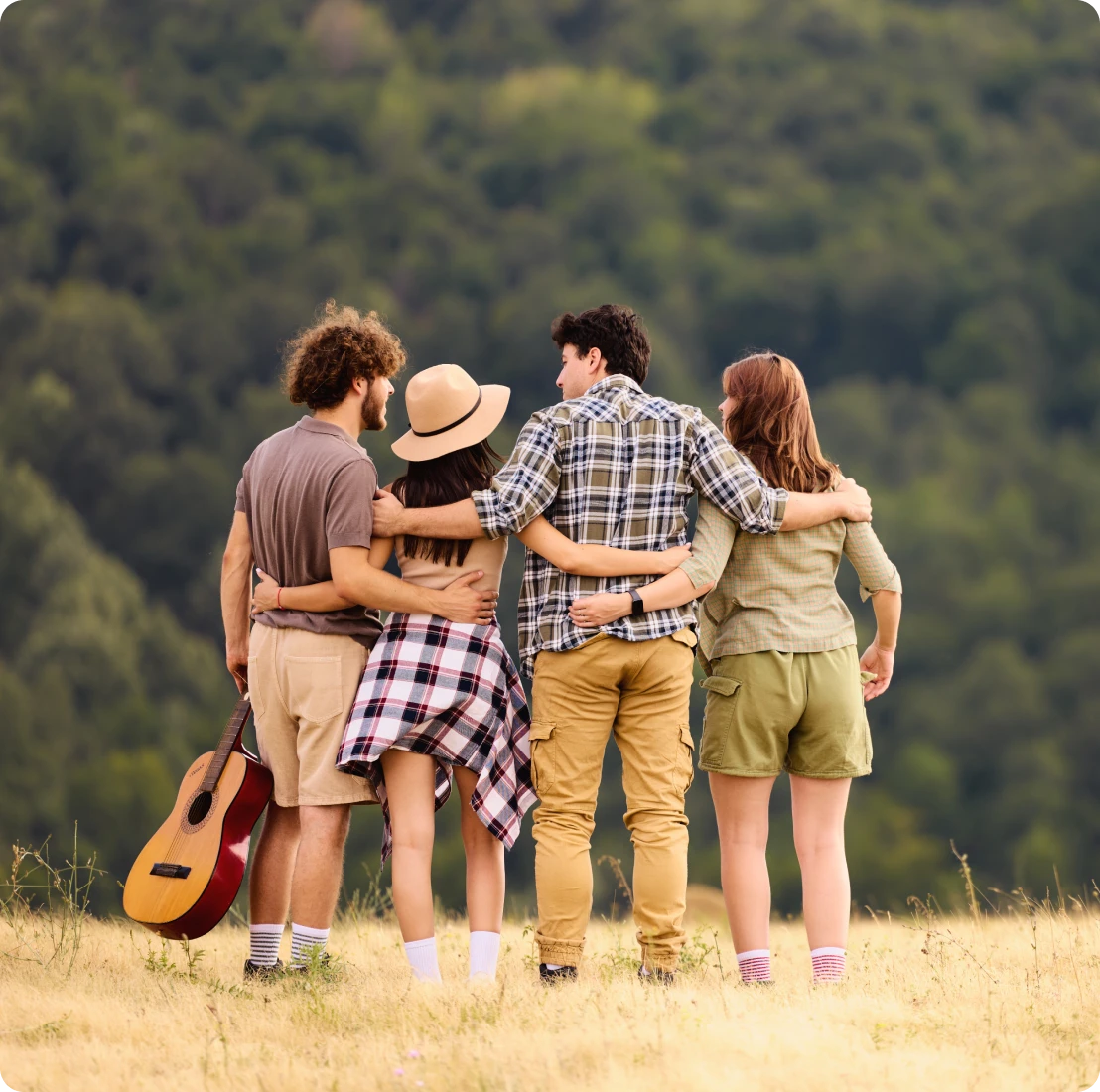 Friends embracing in a scenic field