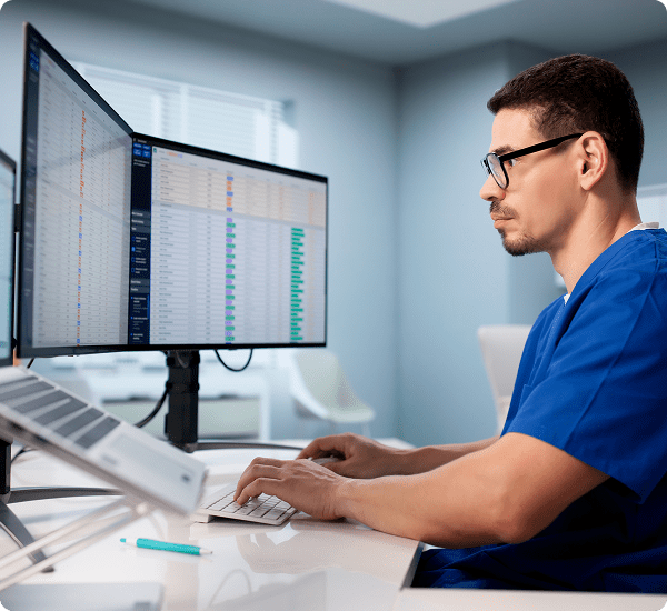 Man working on dual computer screens